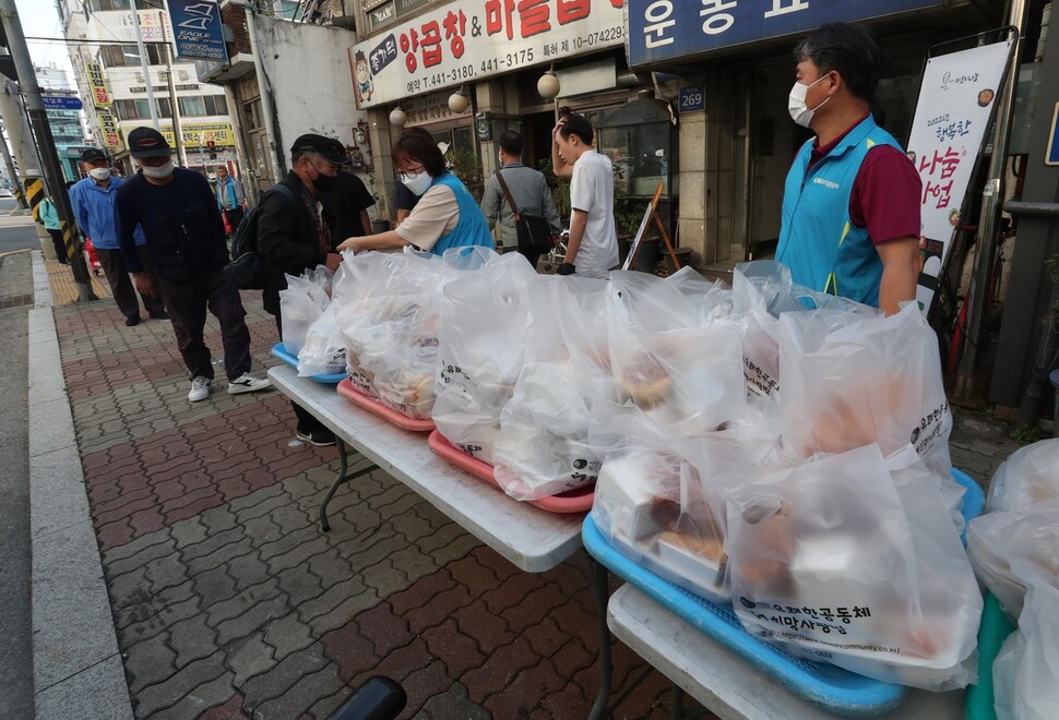 유쾌한공동체 활동가와 자원봉사자들이 무료도시락을 나눠주고 있다. 박종식 기자