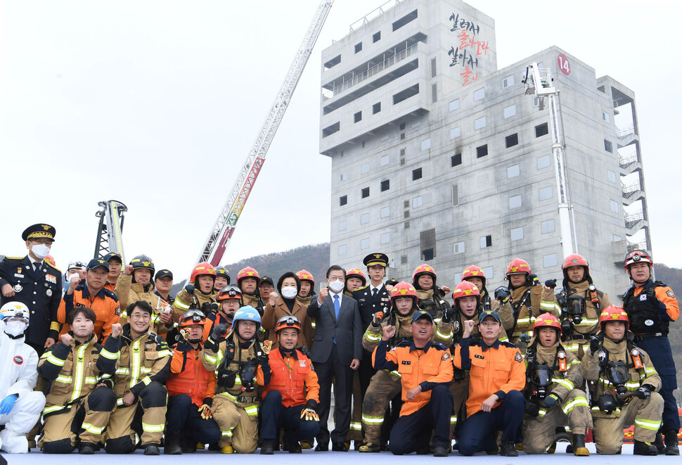 문재인 대통령이 6일 오전 충남 공주시 중앙소방학교 화재진압훈련장에서 열린 제58주년 소방의 날 기념식에 참석해 화재진압 시범을 보인 소방관들과 기념사진을 찍고 있다. 공주/청와대사진기자단