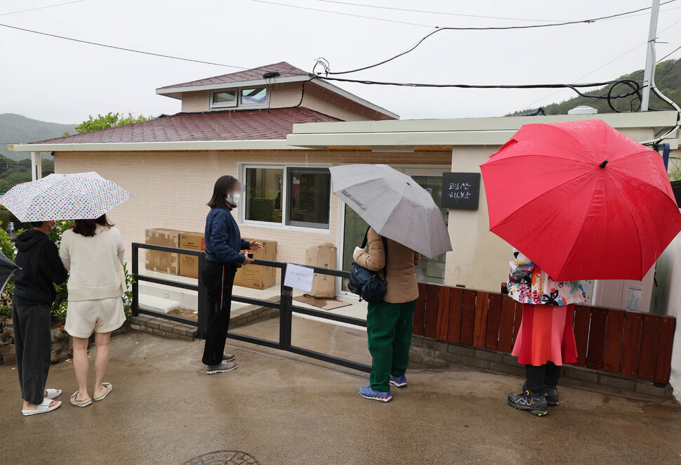 평산마을을 찾은 주민과 시민들이 비가 내리는 가운데 ‘평산책방’을 둘러보고 있다. 백소아 기자