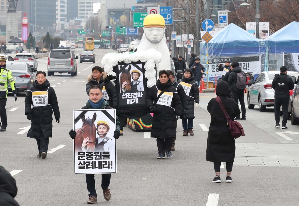 마사회 고 문중원 기수 죽음의 진상규명과 책임자 처벌을 위한 시민대책위원회 위원들이 6일 오전 서울 종로구 정부서울청사 인근 추모분향소를 출발해 청와대로 헛상여를 메고 행진하고 있다. 백소아 기자