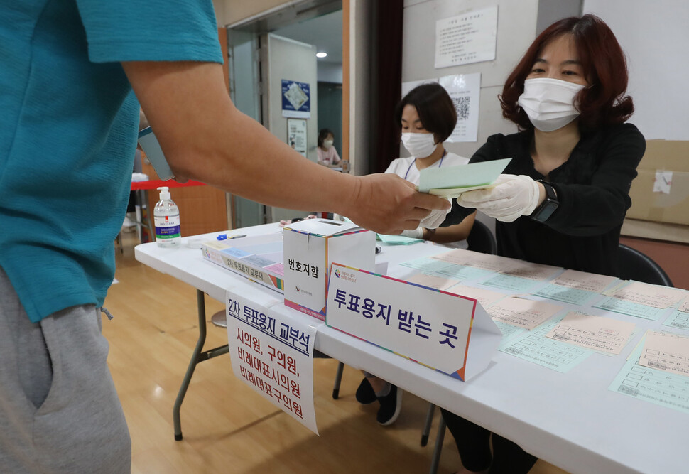 제8회 전국동시지방선거일인 1일 오전 서울 서초구 방배1동주민센터에서 1차 투표를 마친 유권자들이 2차 투표용지를 받고 있다. 신소영 기자