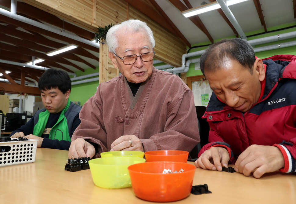 우리마을 촌장인 김성수 주교가 발달장애인들이 두꺼비집 부품을 조립하는 모습을 바라보고 있다. 강재훈 선임기자 khan@hani.co.kr