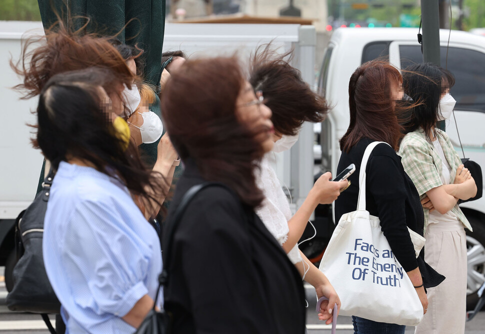 중부지방에 많은 비와 강풍이 예보된 28일 오전 서울 광화문광장에서 시민들이 바람을 맞으며 걸어가고 있다. 연합뉴스