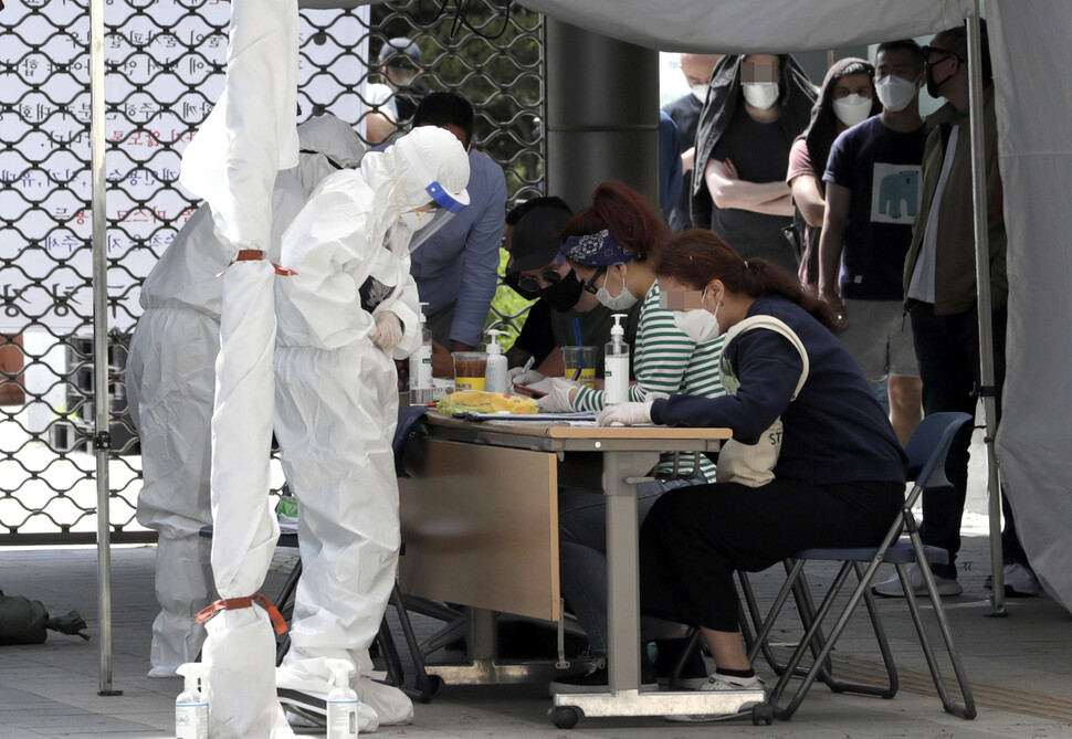 11일 오후 서울 용산구보건소 선별진료소에서 검사를 원하는 사람들이 문진표를 작성하고 있다. 김혜윤 기자