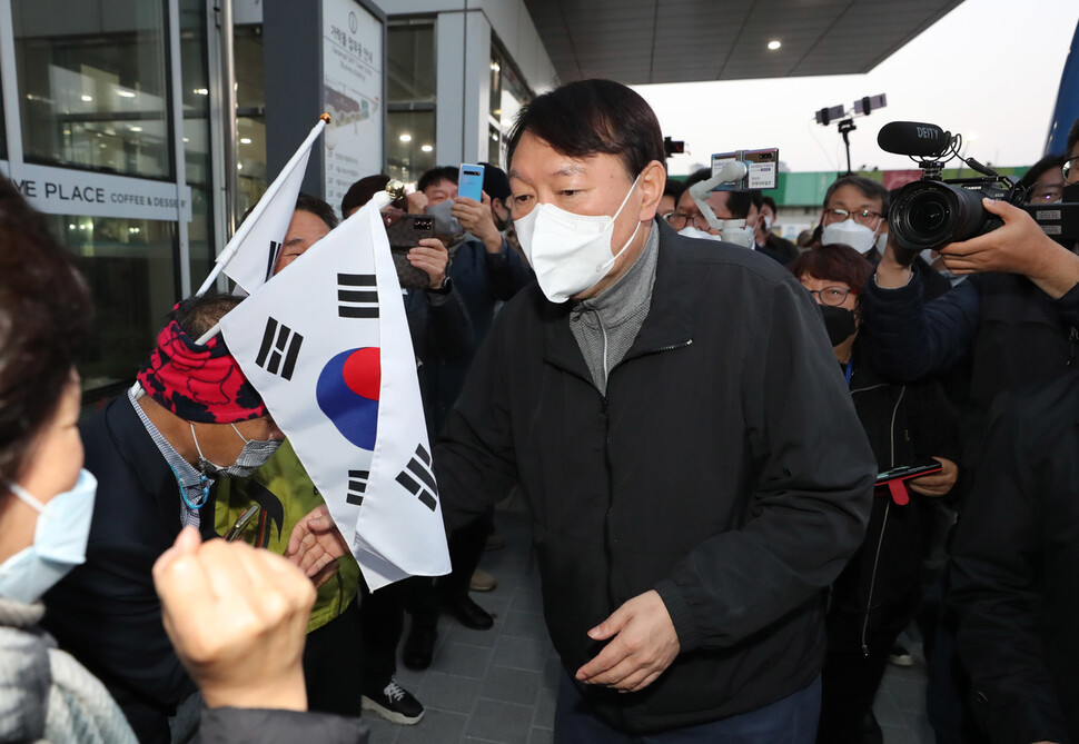 국민의힘 윤석열 대선 후보가 6일 아침 7시 서울 송파구 가락농수산물종합도매시장을 찾아 태극기를 든 지지자들과 인사하고 있다. 연합뉴스