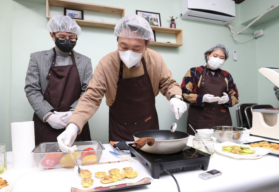 국민의힘 윤석열 대선후보(가운데)가 24일 서울 구로구 부일로 고아권익연대 사무실에서 보육 시설 퇴소 청년들에게 보낼 반찬 나눔 봉사활동을 하고 있다. 왼쪽은 조윤환 고아권익연대 대표. 공동취재사진