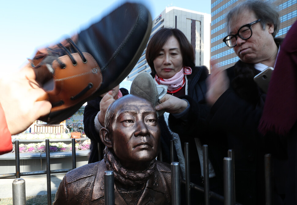 신군부가 일으킨 12·12 군사반란 40주년인 12일 5·18 관련 단체 회원들이 서울 광화문광장에서 전두환 씨의 구속 수사를 촉구하는 기자회견을 한 뒤 이를 상징적으로 표현하기 위해 제작한 동상 조형물을 때리는 행위를 하고 있다. 이종근 기자