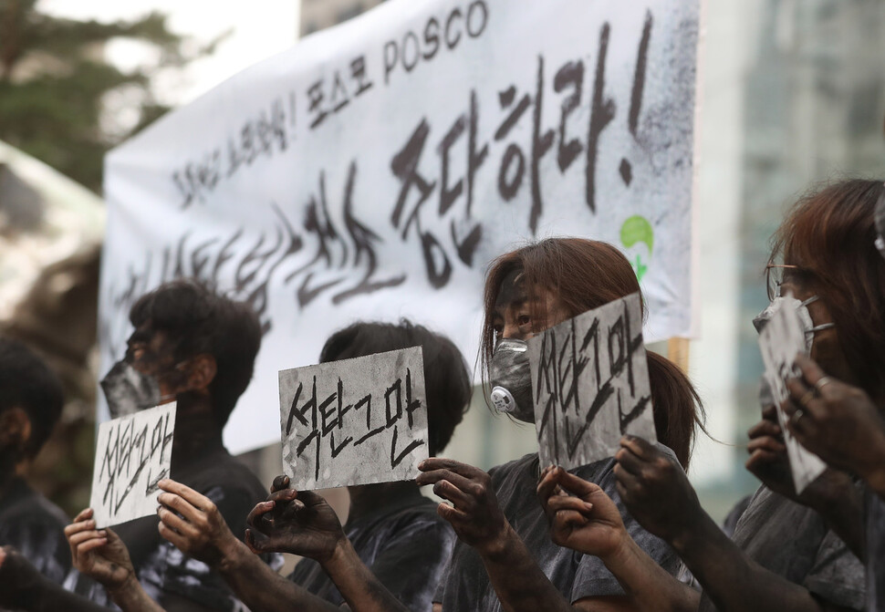 녹색연합과 이제석광고연구소 관계자들이 18일 오전 포스코의 석탄 발전소 건설 중단을 촉구하는 손팻말을 들고 있다. 신소영 기자