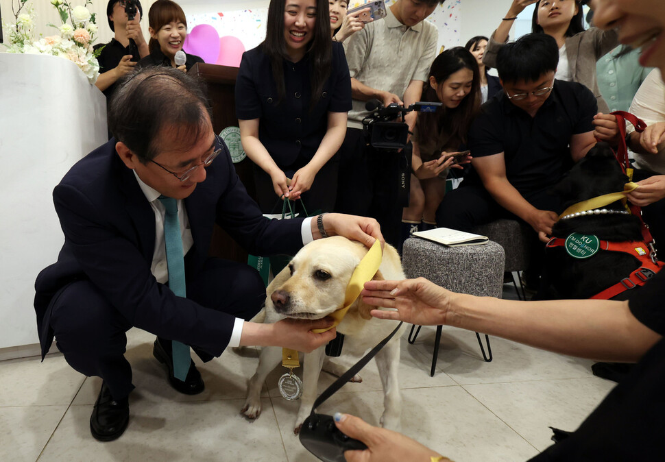 학교 관계자가 은퇴견에게 감사의 메달을 수여하고 있다. 윤운식 선임기자