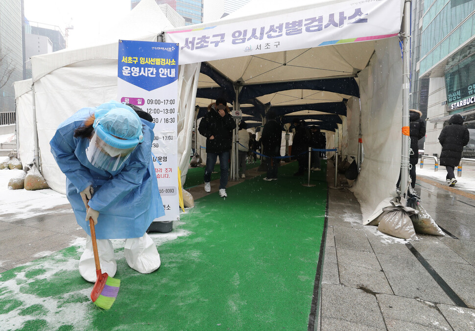 19일 오전 서울 서초구 강남역 임시선별검사소에서 직원이 검사소 출구 쪽에 쌓인 눈을 쓸어내고 있다. 김태형 기자 xogud555@hani.co.kr