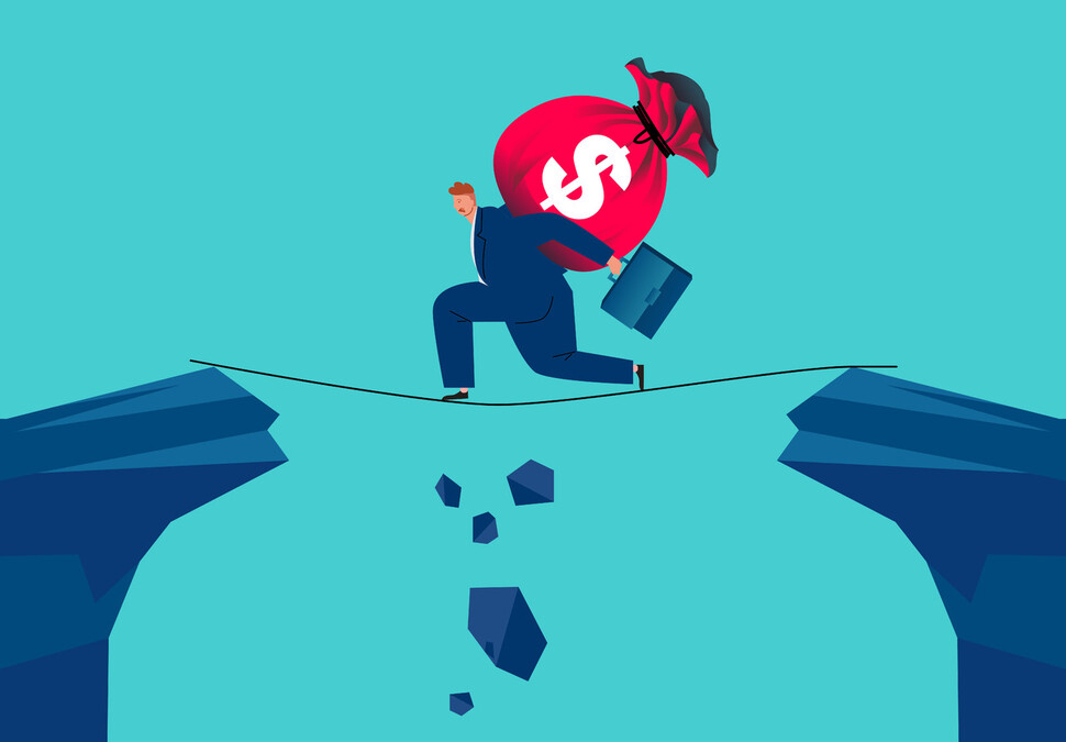 Businessman carrying money bag on his shoulder walking on the rope through the abyss, concept of financial risk