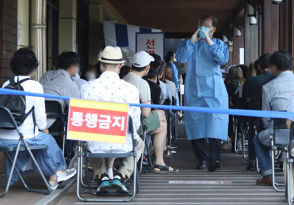 8일 송파구 보건소 선별진료소가 코로나19 검사를 받는 시민들로 붐비고 있다. 지난 7일 송파구 보건소 인근의 롯데월드는 확진자 방문으로 영업을 중단했다. 연합뉴스