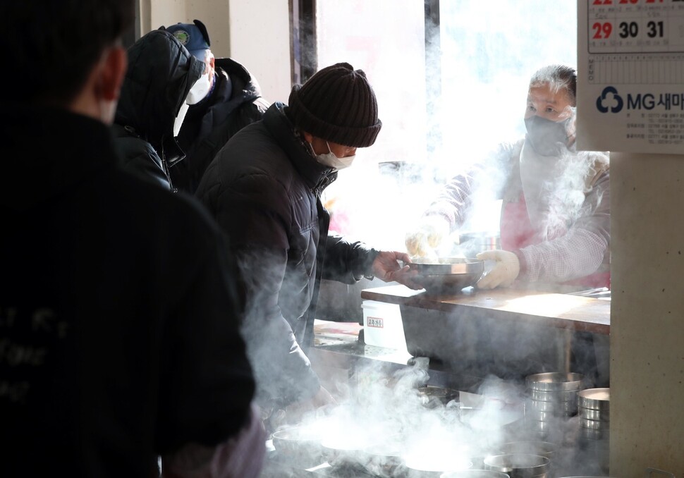 25일 낮 서울 종로구 탑골공원 원각사 무료급식소에서 자원봉사자들이 점심을 배식하고 있다. 박종식 기자