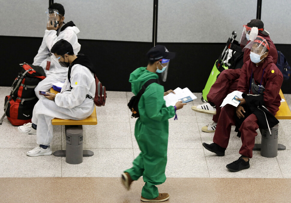 정부가 새로운 코로나19 변이 바이러스인 오미크론에 대응하기 위해 남아프리카공화국 등 아프리카 8개국에서 들어오는 모든 외국인의 입국을 제한하고 해당국에서 온 내국인을 시설 격리하는 등 변이 바이러스 유입 차단 조처를 시행한 28일 오전 인천 영종도 인천국제공항 제1여객터미널에서 방역복을 입은 해외 입국자들이 입국 절차를 밟고 있다. 인천공항/김명진 기자 littleprince@hani.co.kr