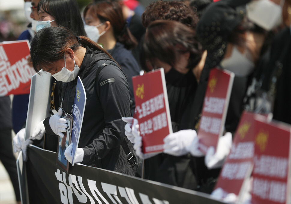 29일 청와대 분수대 앞에서 열린 '이천 물류창고 중대재해 책임자 한익스프레스 처벌 촉구 기자회견'에서 희생자 유가족이 영정 속 희생자를 어루만지고 있다. 사진 연합뉴스