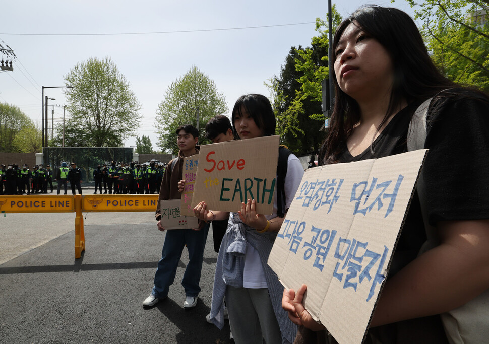 행진을 마친 참가자들이 서울 용산구 미군기지 14번 게이트 앞에서 반환기지 오염정화를 요구하는 손팻말을 들고 있다. 김혜윤 기자