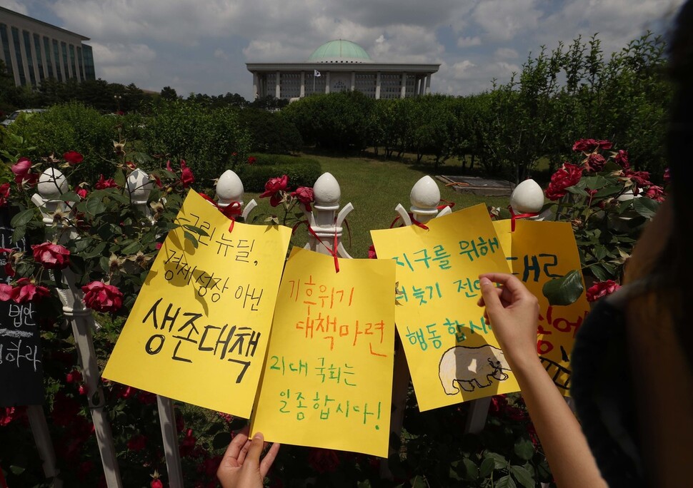 기후위기 비상행동 회원들이 11일 오전 국회 정문에 기후위기비상선언 결의안 채택과 기후재난 대응 정책 우선 추진을 촉구하는 내용의 팻말을 달고 있다. 박종식 기자 anaki@hani.co.kr