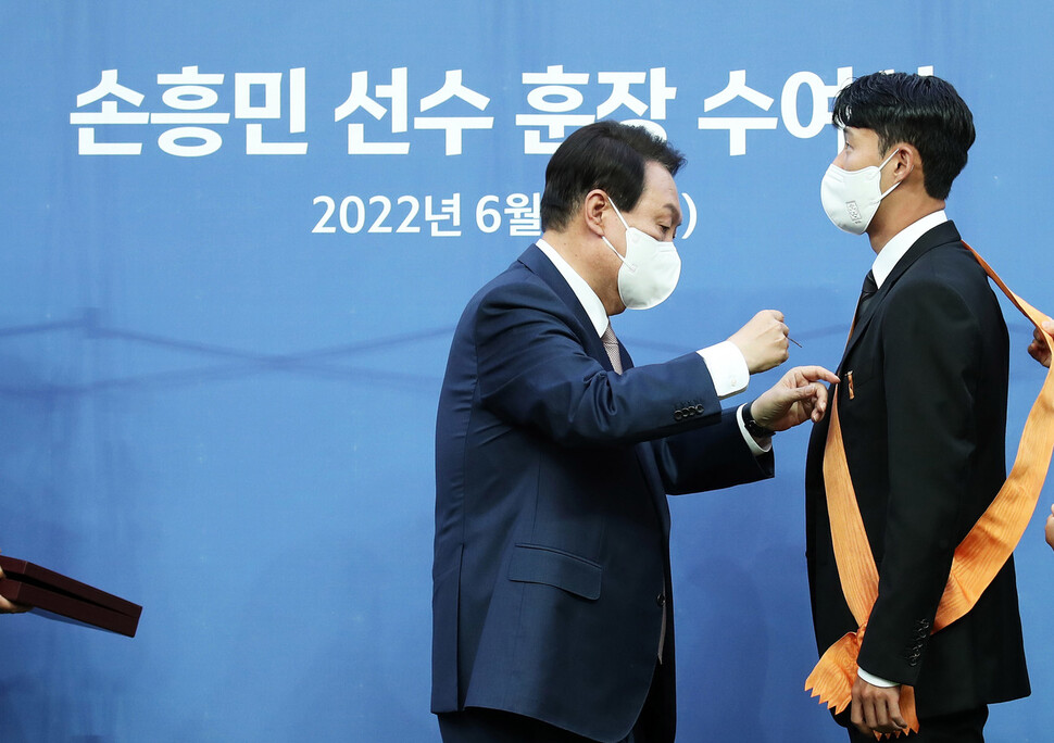 윤석열 대통령이 2일 서울월드컵경기장에서 2002 한일월드컵 20주년 기념 평가전 대한민국-브라질의 경기에 앞서 잉글랜드 프로축구 프리미어리그(EPL)에서 아시아 선수 최초로 득점왕을 차지한 손흥민에게 체육훈장 최고등급인 청룡장을 수여하고 있다. 대통령실사진기자단