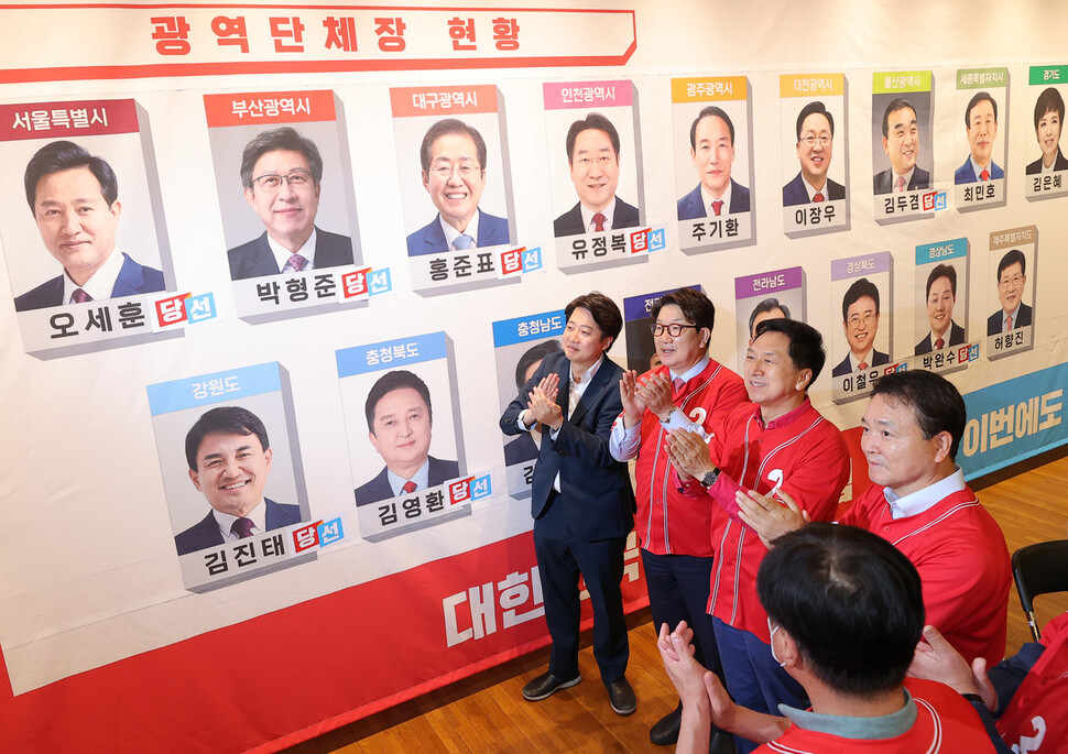 1일 서울 여의도 국회도서관에 마련된 ‘국민의힘 제8회 지방선거 개표상황실’에서 이준석 상임선대위원장과 권성동 공동선대위원장 등 당 지도부가 당선이 확실시 된 후보들 사진에 스티커를 붙인 뒤 박수를 치고 있다. 공동취재사진