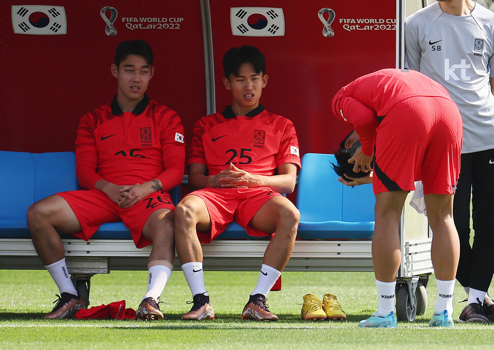 한국 남자축구 대표팀 주장 손흥민(오른쪽)이 16일(현지시각) 오전 카타르 도하 알 에글라 훈련장에서 얼굴 부상 회복을 위해 마스크를 쓰는 모습을 송민규(왼쪽)와 정우영이 지켜보고 있다. 도하/김혜윤 기자 unique@hani.co.kr