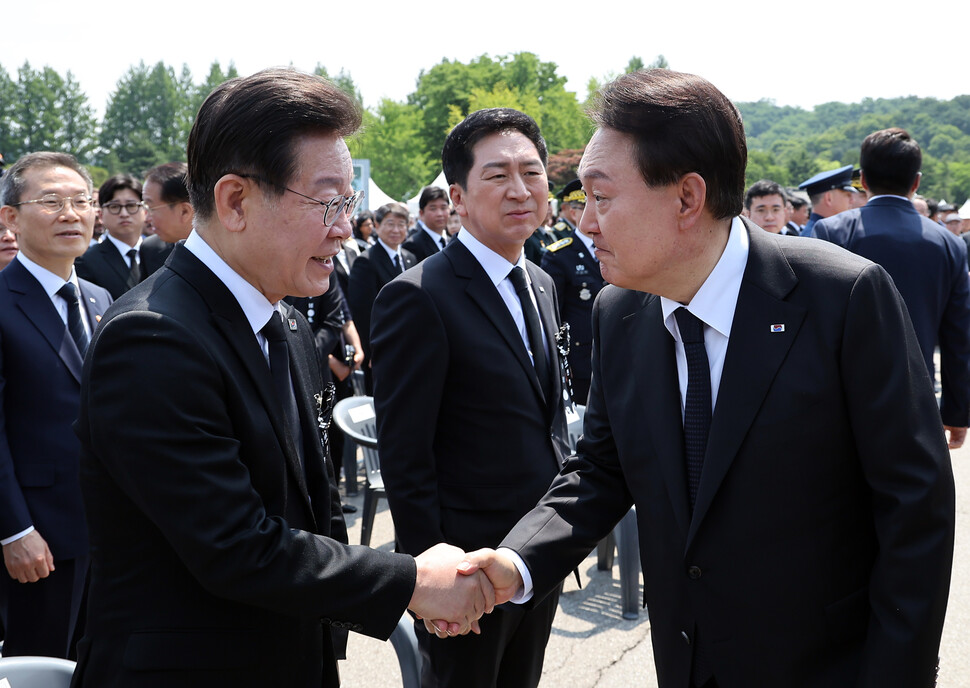 윤석열 대통령이 6월6일 서울 동작구 국립서울현충원에서 열린 제68회 현충일 추념식에서 이재명 더불어민주당 대표와 악수하고 있다. 연합뉴스