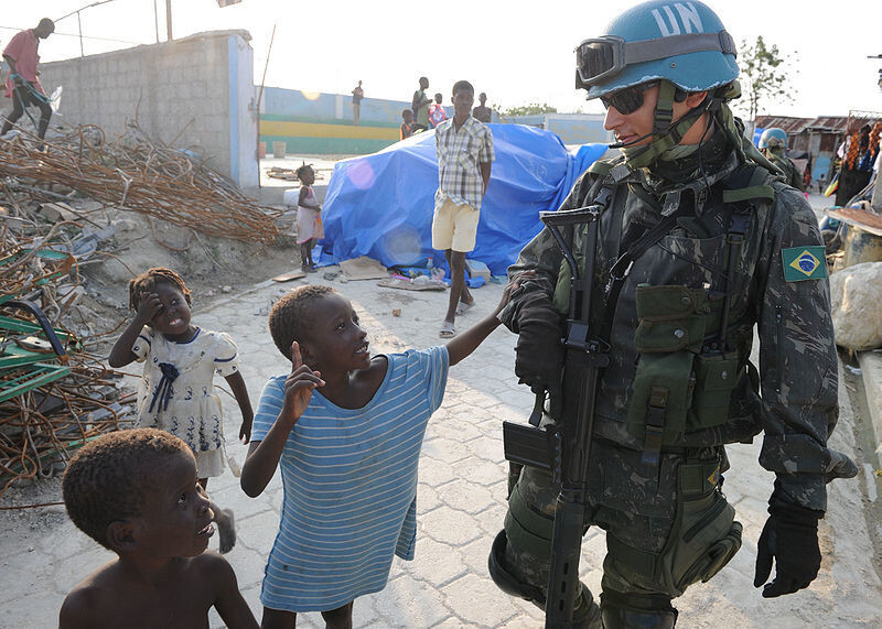 2010년 아이티를 강타한 지진 피해의 복구와 지원에 투입된 ‘유엔 아이티 안정화 지원단(MINUSTAH)’ 소속의 브라질 군인에게 아이들이 뭔가를 말하고 있다. 위키피디아
