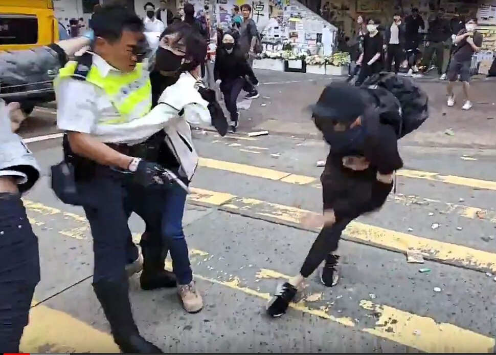 홍콩 교통경찰이 11일(현지시각) 오전 홍콩섬 북서부 사이완호에서 ‘3파’(학생 동맹휴업, 노동자 파업, 상인 철시)를 위해 출근길 교통방해 시위에 참가한 시위대와 몸싸움을 벌이며 해산 작업을 벌이다가 자신을 향해 다가서는 20대 청년에게 권총을 발사해 이 남성이 복부에 총상을 입고 쓰러지는 장면이 영상에 포착됐다. 홍콩/AFP 연합뉴스