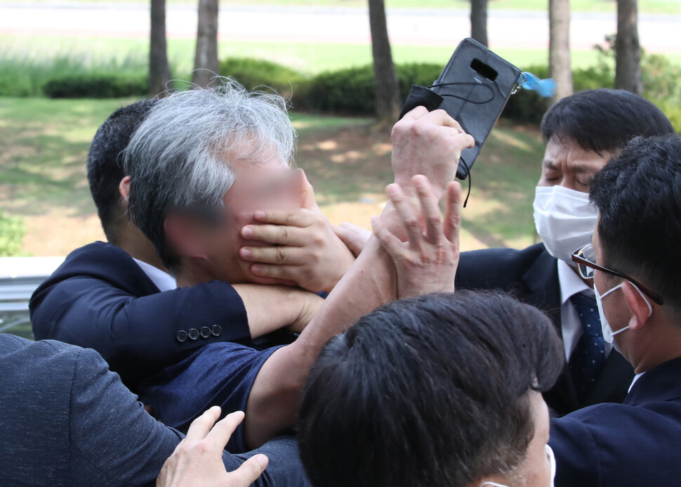 대통령 경호원들이 16일 오후 서울 여의도 국회에서 열린 제21대 국회 개원식에 참석한 문재인 대통령을 향해 신발을 던지고 소리를 지르는 시민의 입을 막고 있다. 연합뉴스