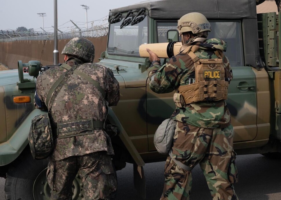 지난 7일 한국 공군 장병(왼쪽)이 드론을 향해 소총을 겨누고 있는 가운데 미군 장병이 드론을 무력화할 수 있는 무선 주파수 교란장비인 드론버스터를 사용하고 있다. 미군 군산기지 누리집