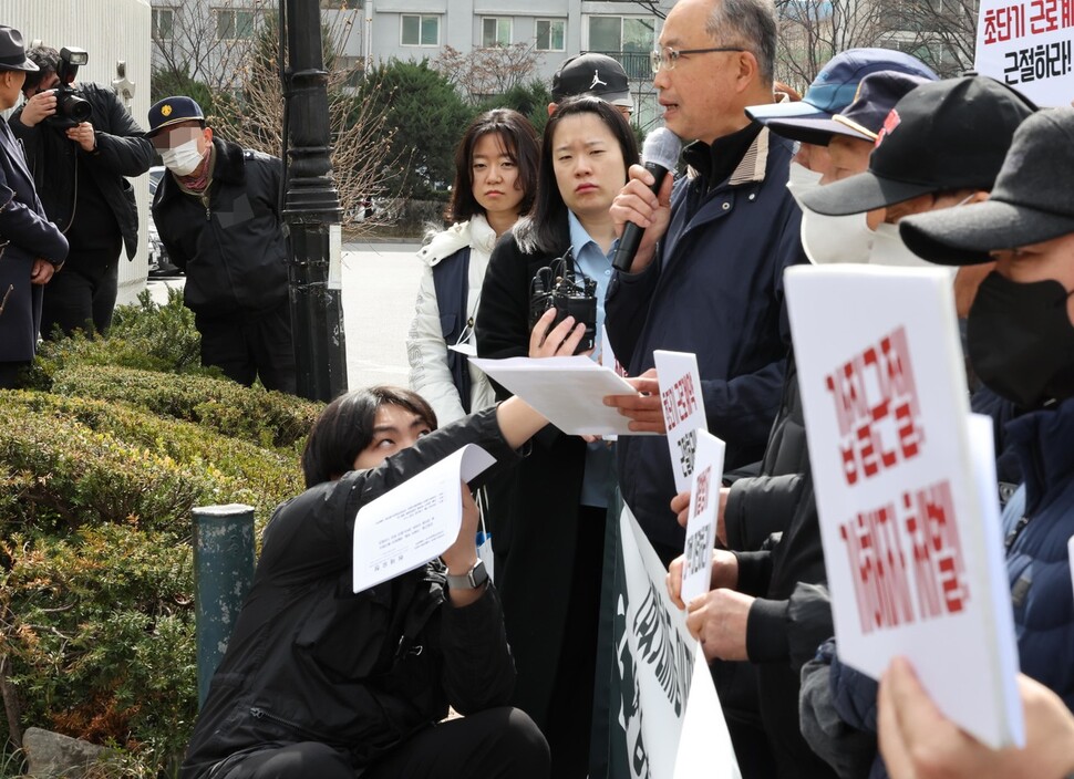 17일 오전 관리자의 ‘갑질’을 폭로하는 내용의 유서를 남기고 극단적 선택을 한 경비노동자가 일했던 서울 강남구 대치동 아파트 앞에서 서울지역 경비노동자와 시민단체 회원들이 추모 기자회견을 열자 이 아파트 경비노동자가 이를 지켜보고 있다. 박종식 기자 anaki@hani.co.kr