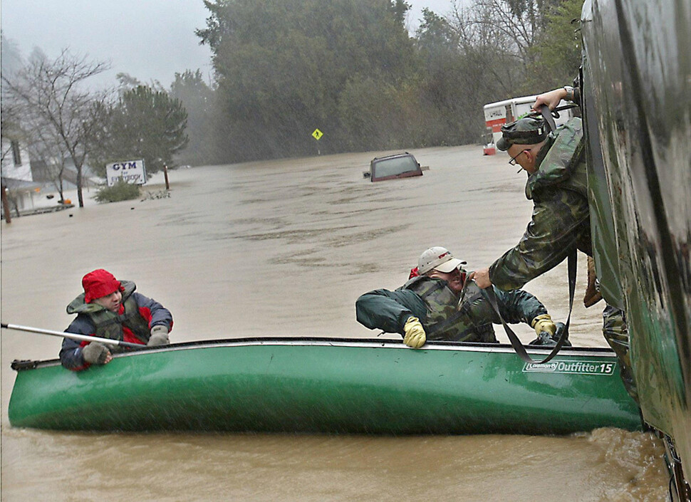 미국 캘리포니아 건빌의 물에 잠긴 도로에서 구조대원들이 커누를 타고 접근해 피난민을 구조하고 있다. 카본 브리프 제공