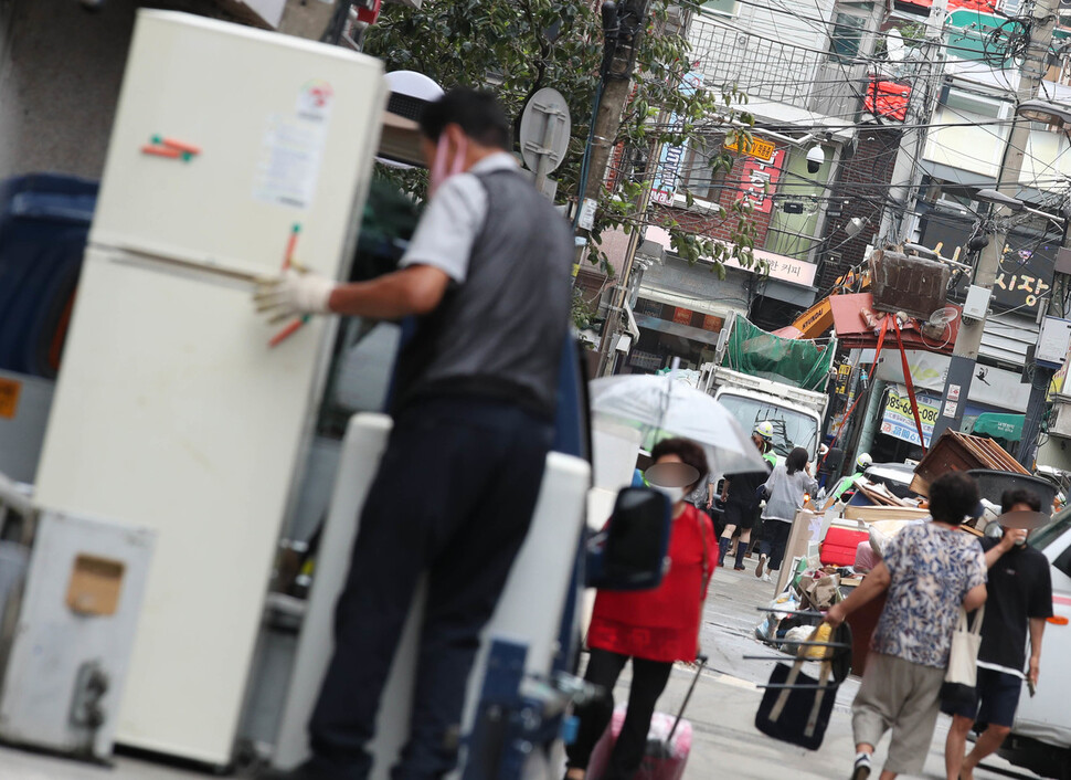 11일 오전 서울 관악구 신사동 일대 빌라촌 골목길에 포크레인이 쌓여있는 수해 쓰레기를 청소차량으로 옮기고 있다. 이날 오전 청소차량 38대, 포크레인 9대가 투입돼 거리에 쏟아진 수해쓰레기를 치웠다. 백소아 기자