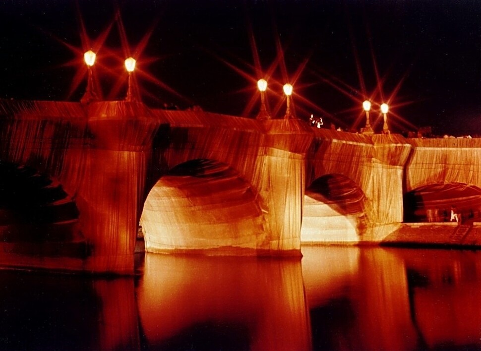 환경예술가인 크리스토와 부인인 잔클로드는 1985년 2주 동안 퐁 뇌프 다리 전체를 천으로 감싼 작품을 선보였다. 작품 전시 당시 천으로 싸인 퐁 뇌프의 야경 모습. 위키피디아