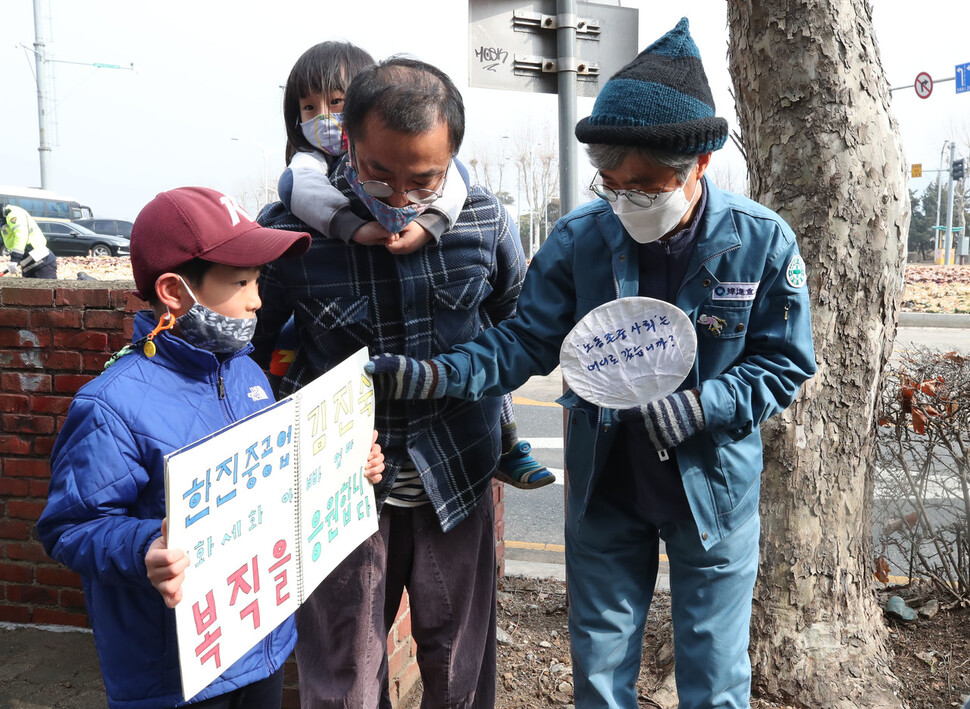 6일 오후 경기도 과천시 남태령 고개 인근에서 한 가족이 직접 준비한 손팻말을 들고 김진숙 지도위원을 비롯한 희망뚜벅이 행진을 응원하고 있다. 과천/백소아 기자