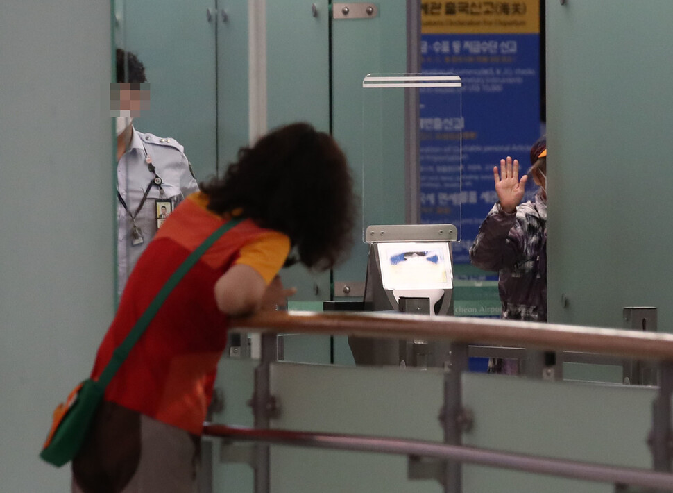 16일 아침 인천국제공항 제1터미널 출국장에서 우한으로 떠나는 한 승객이 가족에게 손을 흔들고 있다. 인천공항/백소아 기자