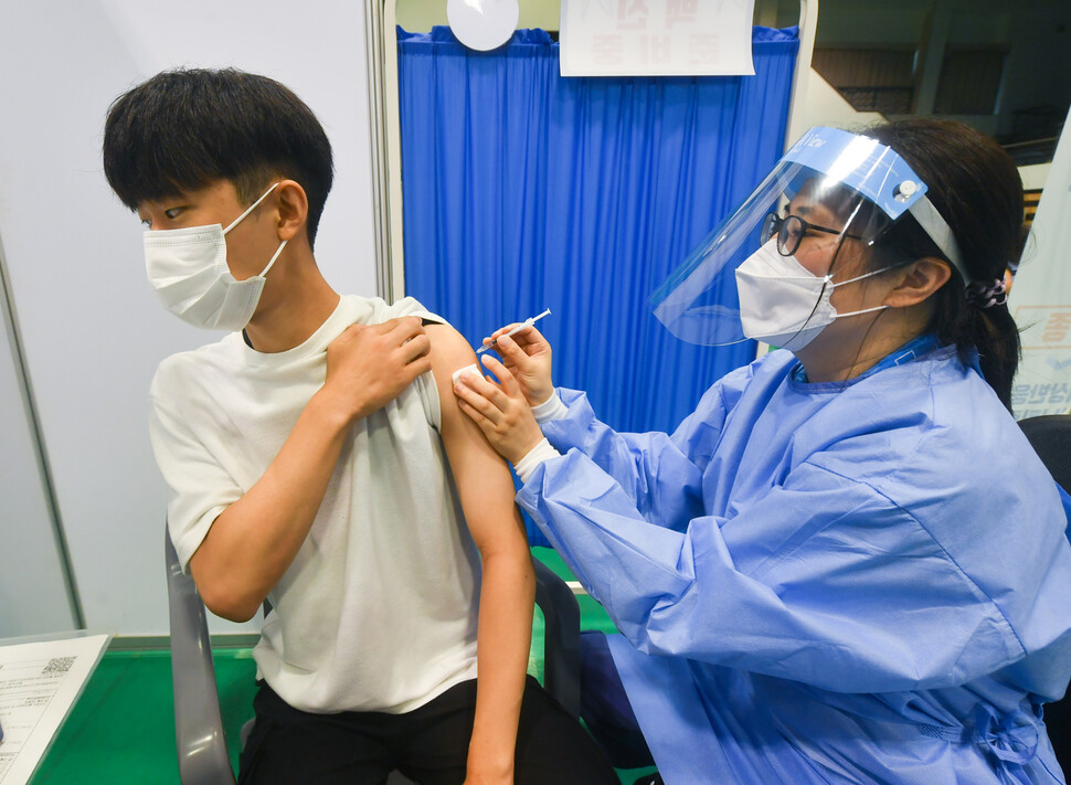 고등학교 3학년 학생 및 교직원 등에 대한 백신 접종이 시작된 19일 오전 경기도 수원시 영통구 아주대학교 체육관에 설치된 수원시 코로나19 예방접종센터에서 고3 학생이 화이자 백신을 접종받고 있다. 연합뉴스