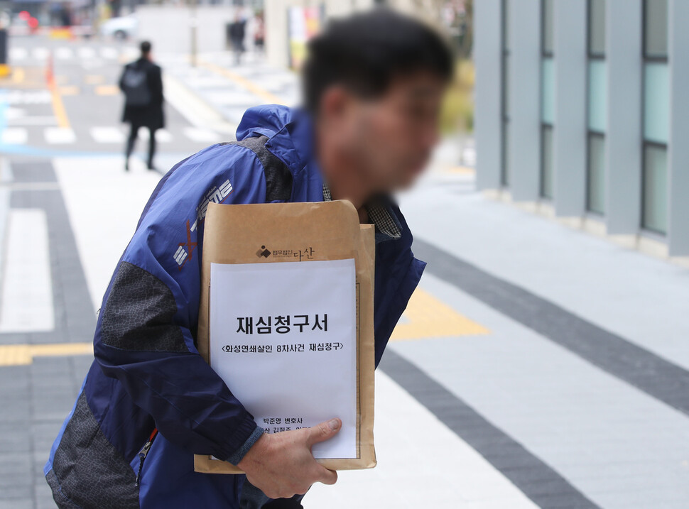 이춘재 연쇄살인 사건의 범인으로 몰려 20년 동안 ‘억울한 옥살이’ 한 윤성여(54)씨가 2019년 11월13일 재심청구서를 들고 수원지방법원으로 들어가고 있다. 연합뉴스.
