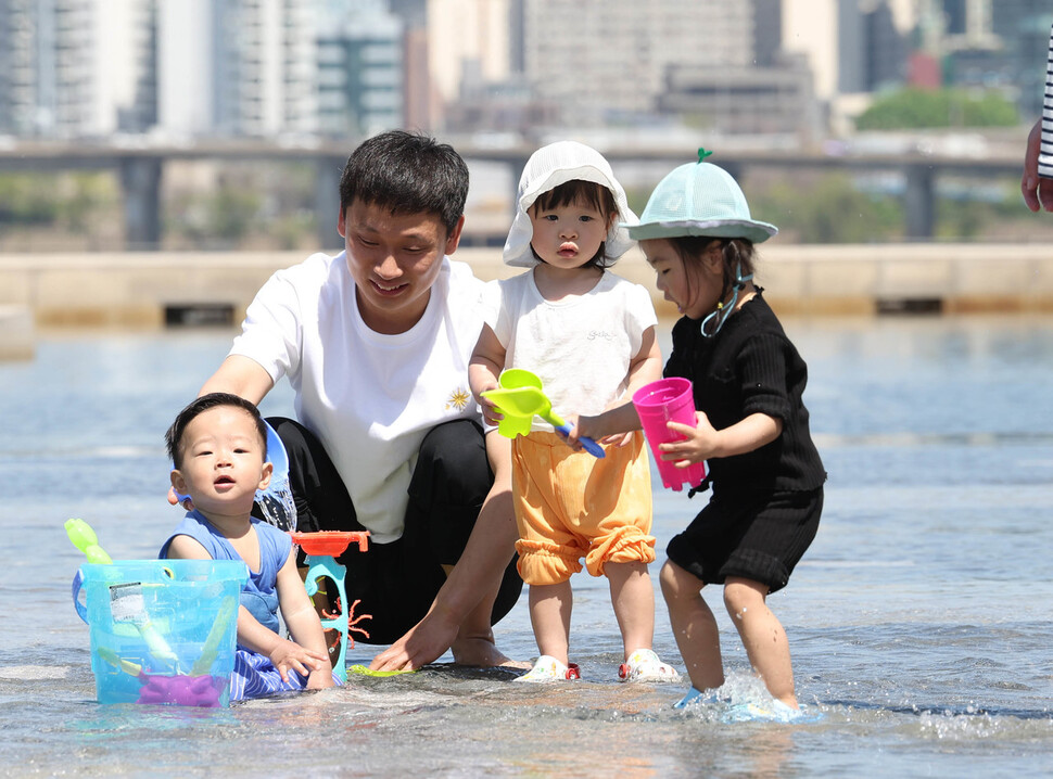 서울 한낮 기온이 25도를 넘은 19일 낮 서울 영등포구 여의도 물빛광장에서 어린이들이 물놀이하고 있다. 백소아 기자