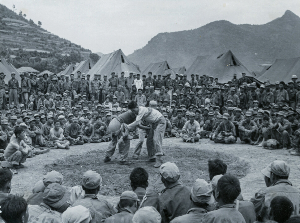 1951년 6월 거제 포로수용소에서 국제적십자위원회 지원으로 열린 체육대회에서 씨름대결을 지켜보는 포로들.