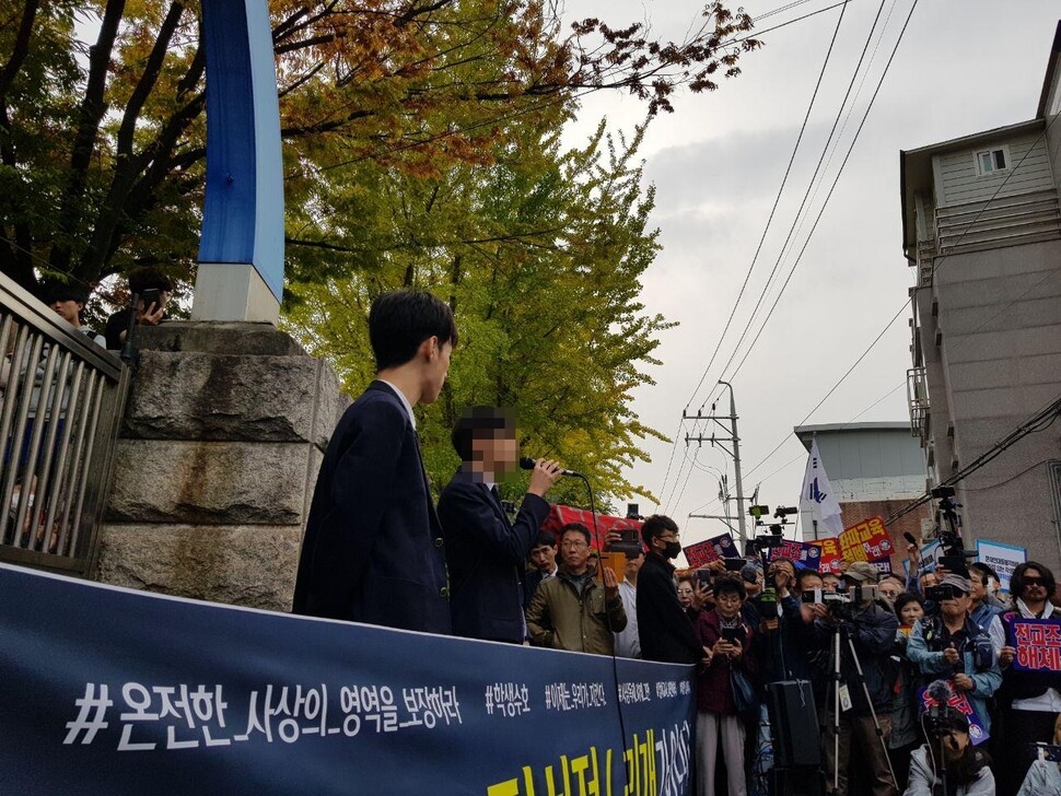 23일 서울 관악구 인헌고 앞에서 열린 ‘인헌고등학교 학생수호연합’의 기자회견에서 대변인 최아무개(18·마이크 든 이)군이 발언하고 있다.