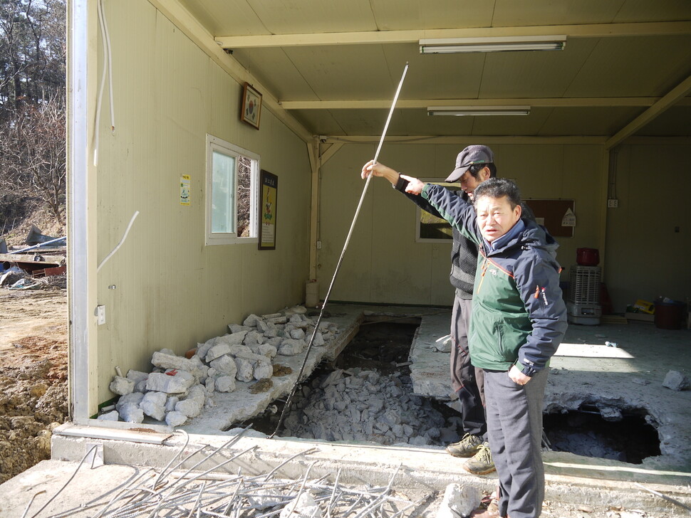 지난해 12월14일 비료공장 금강농산 식당 건물 지하에서 긴 막대기에 묻어나온 검은 물질을 최재철 위원장이 가리키고 있다.