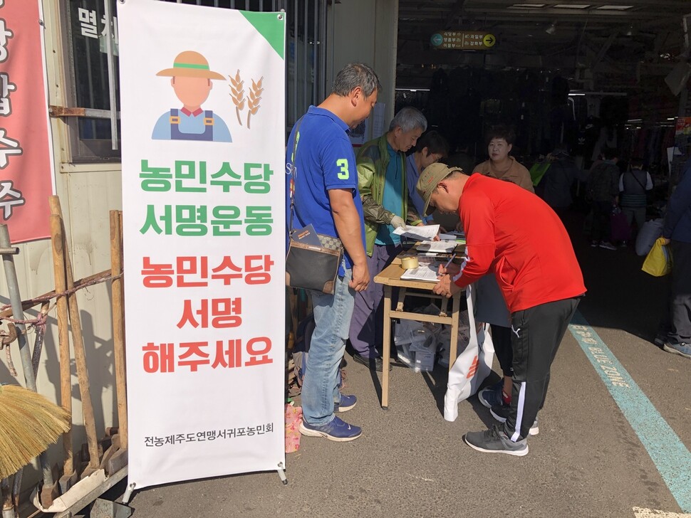 제주 농민수당 조례제정 운동본부가 농민들을 대상으로 농민수당 조례안 주민발의를 위한 청구인 서명을 받고 있다. 운동본부 제공