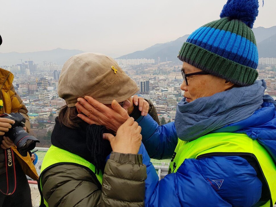 김진숙 민주노총 부산본부 지도위원이 7일간 100㎞를 도보행진한 끝에 29일 대구 영남대의료원 옥상에서 고공농성 중인 해고노동자 박문진씨를 만나 눈물을 닦아주고 있다.