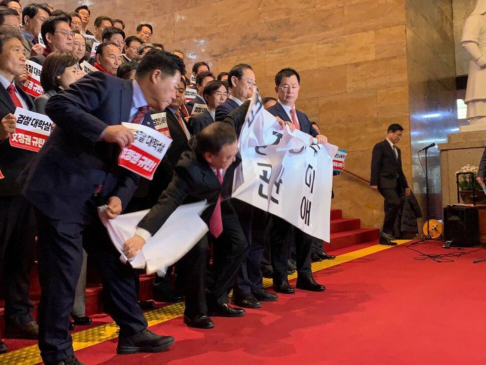 자유한국당 의원들이 9일 국회 중앙홀에서 전날 발표한 검찰 간부 인사에 반발하며 ‘법무장관 추미애’라고 적힌 펼침막을 찢는 퍼포먼스를 벌이고 있다. 이주빈 기자