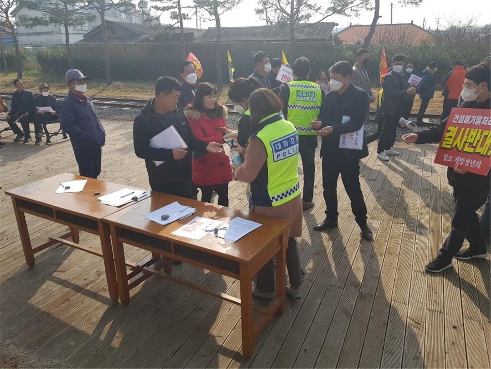 21일 무안군 일로읍에서 열린 건설폐기물처리업체 반대 집회에서 경찰들이 집회 참가자들에게 손소독제를 뿌려주고 있다. 전남지방경찰청 제공