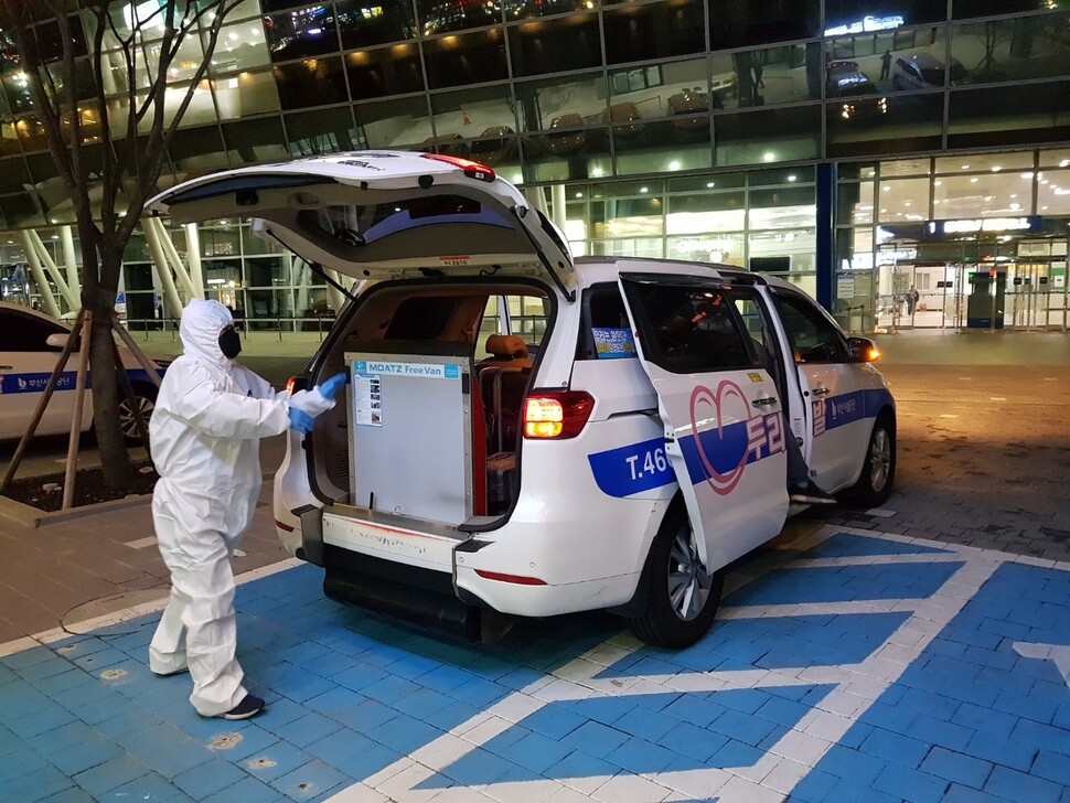 부산역 앞에서 운전기사가 입국자 전용 두리발 택시를 소독하고 있다. 부산시 제공