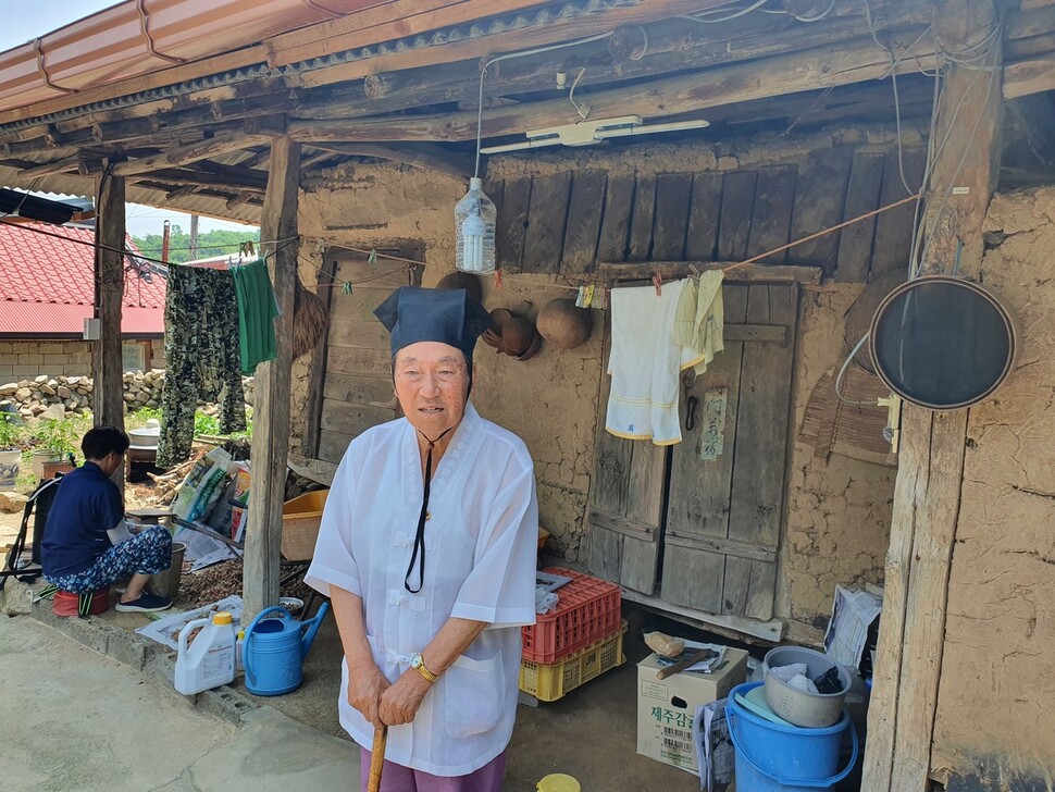 박온섭이 한국전쟁 당시 집의 창고로 쓰던 건물 앞에 서 있다.