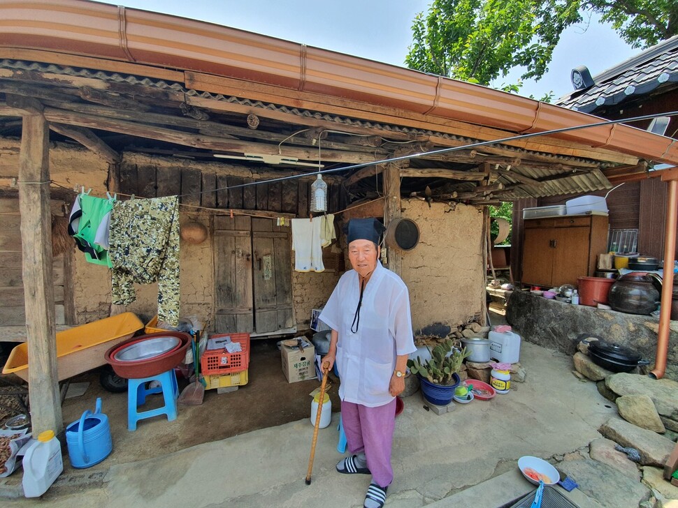 박온섭이 한국전쟁 당시 집의 창고로 쓰던 건물 앞에 서 있다.