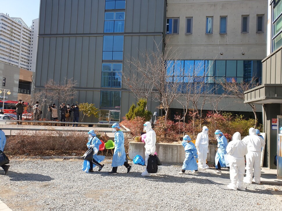 27일 광주시 광산구 운남동의 광주티시에스(TCS)국제학교에서 코로나19 확진 판정을 받은 학생들이 생활치료센터로 가기 위해 이동하고 있다.