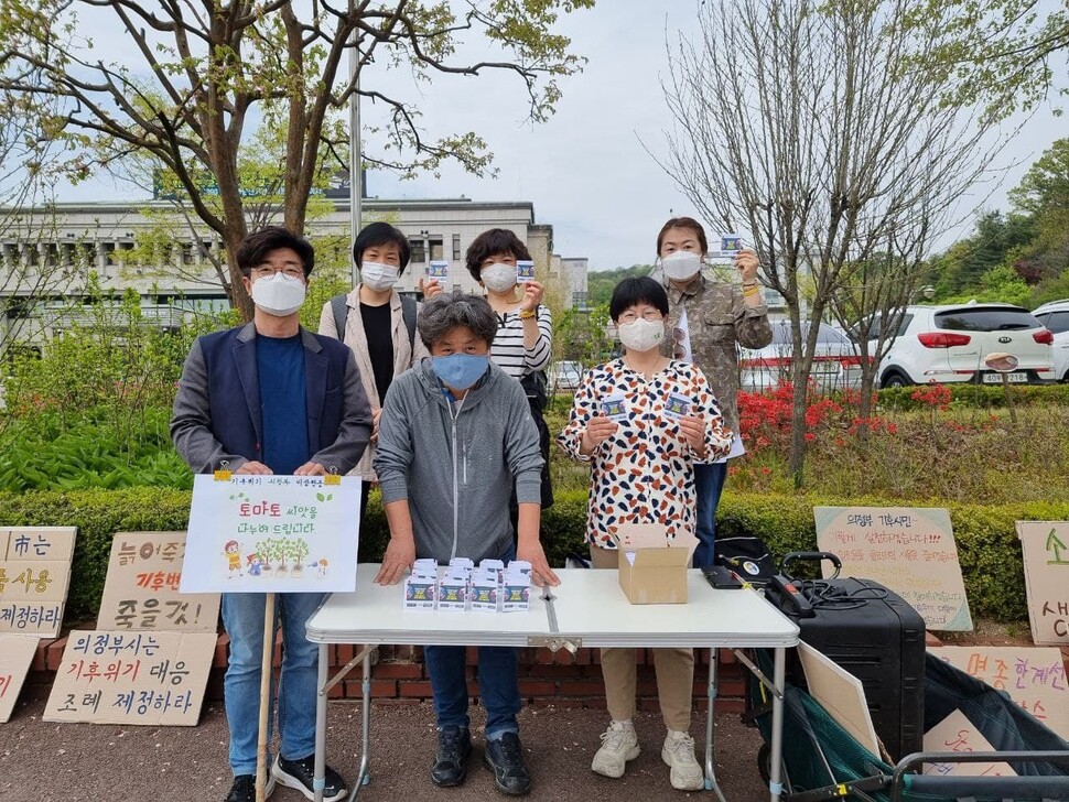 기후위기의정부비상행동 회원들이 22일 오전 의정부시청 앞 광장에서 토마토 씨앗 나누기 행사를 진행한 뒤 의정부시에 기후위기대응조례 제정 등을 촉구하고 있다. 기후위기의정부비상행동 제공